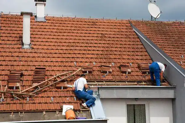Roofing company London engineer inspecting roof tiles for damage